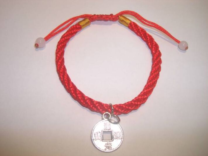 Red thread bracelet with a rare coin to attract happiness